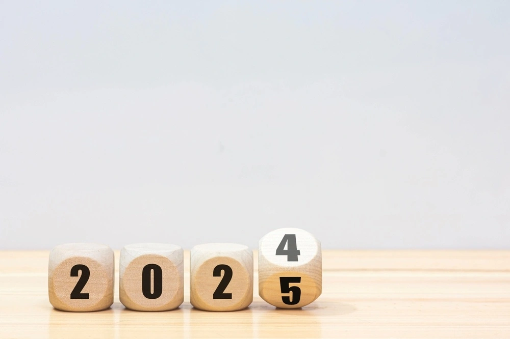 wooden dice showing the year 2024 changing to 2025