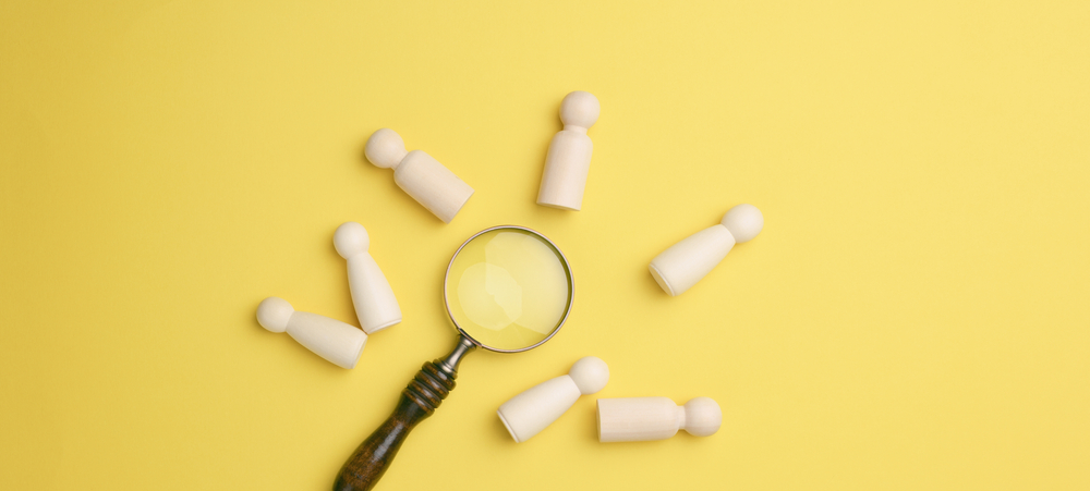 Magnifying glass with chess pieces on a yellow background