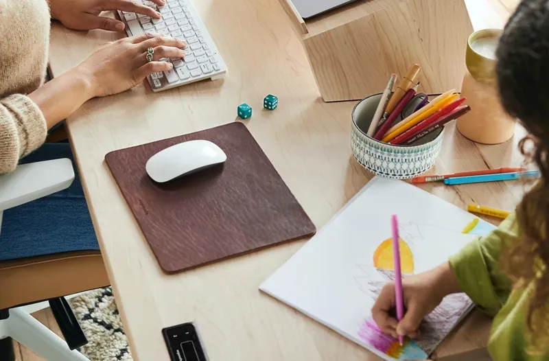 woman at work with-daughter next to her-drawing at her desk