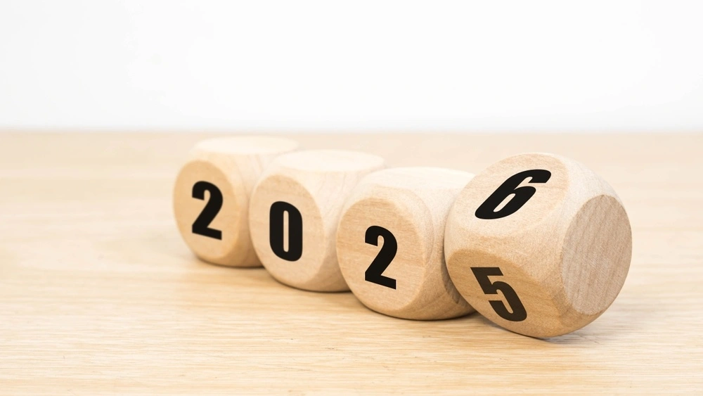 wooden dice rolling from 2025 to 2026