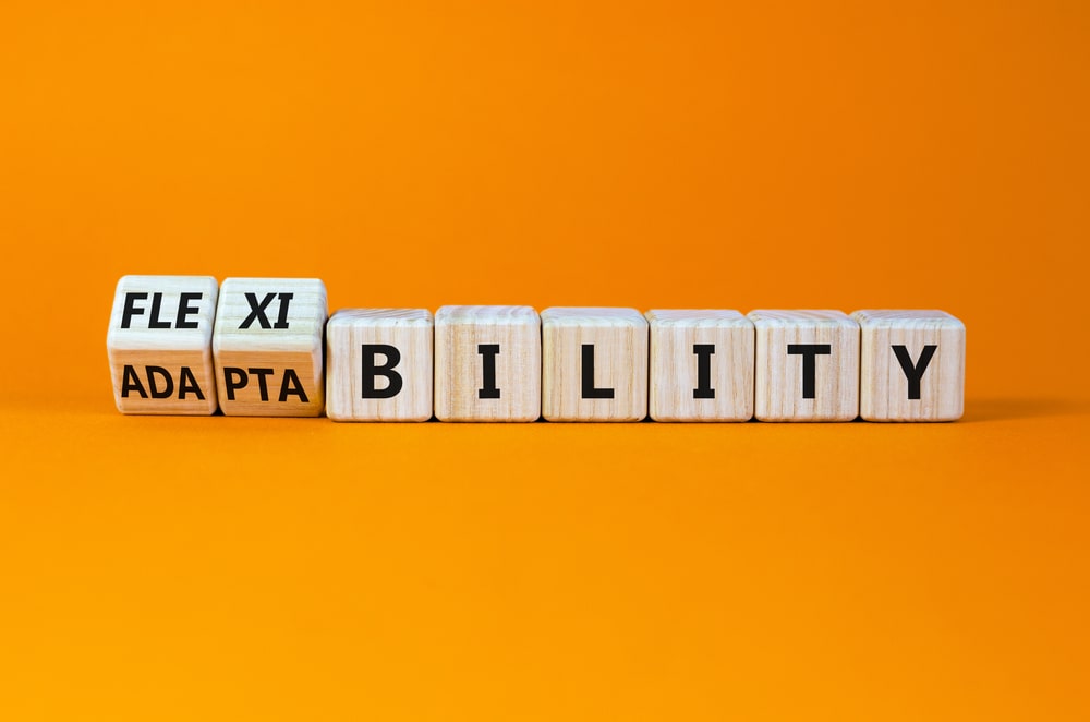 wooden dices spelling the word "flexibility" on orange background